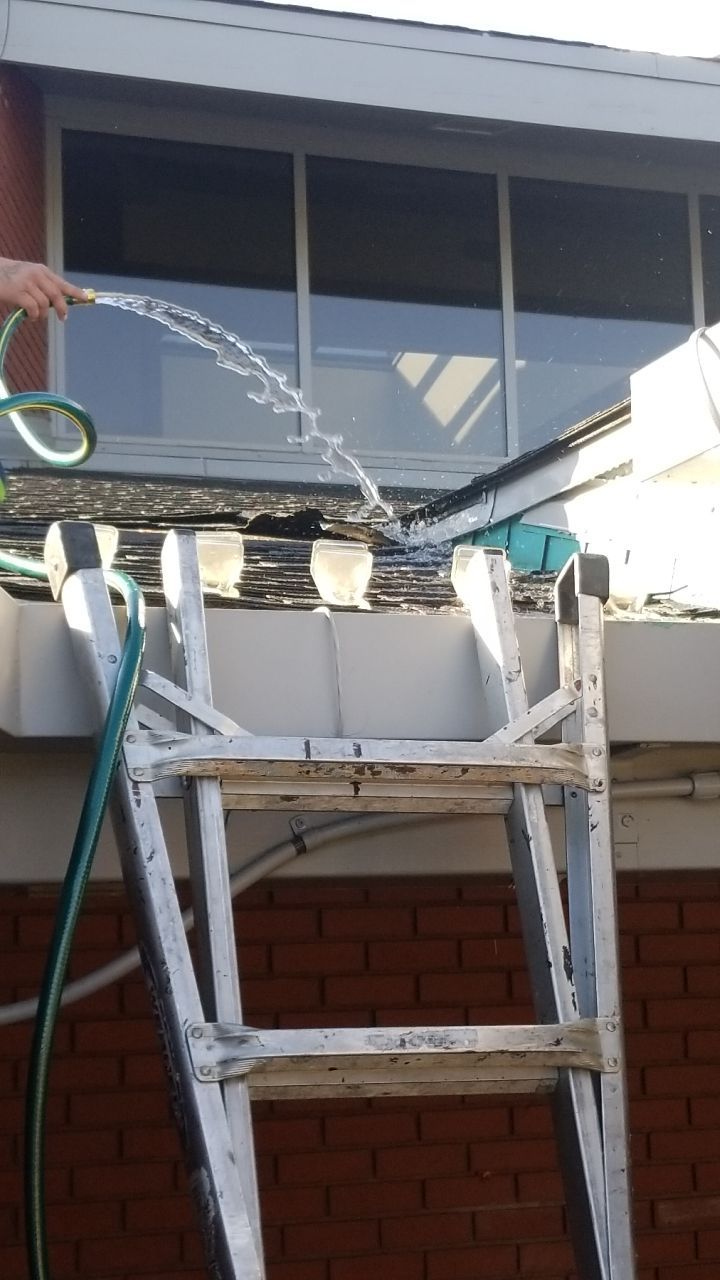 spraying water onto roof with hose